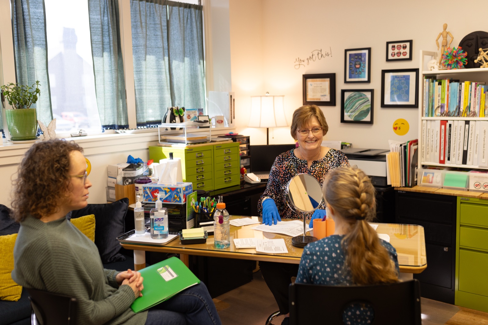 Kathleen reviewing treatment instructions with a patient at her desk